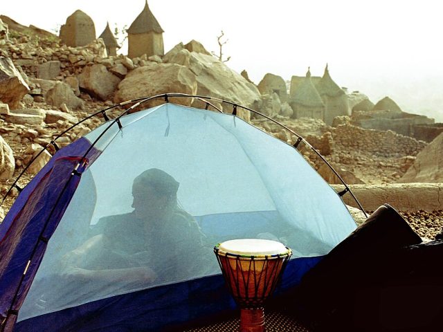 A traveller sleeping under a mosquito net