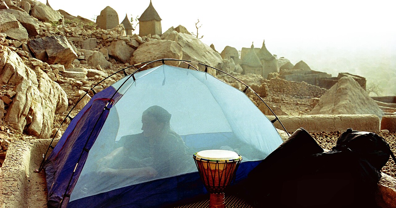 A traveller sleeping under a mosquito net