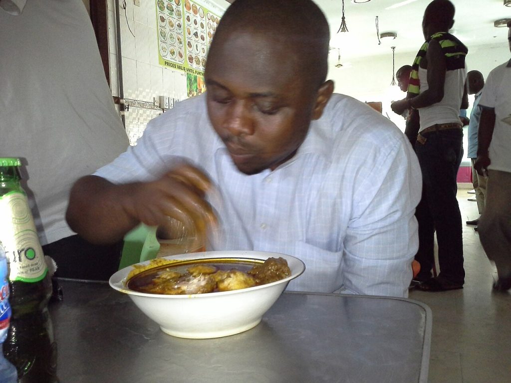 A man eating omo tuo